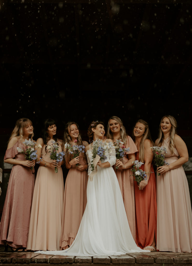 A bride with her bridesmaids laughing during her Asheville mountain wedding. 