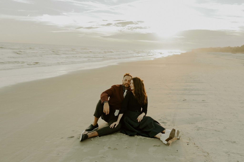 Man and woman sit on the beach for their Hilton Head Beach Elopement.