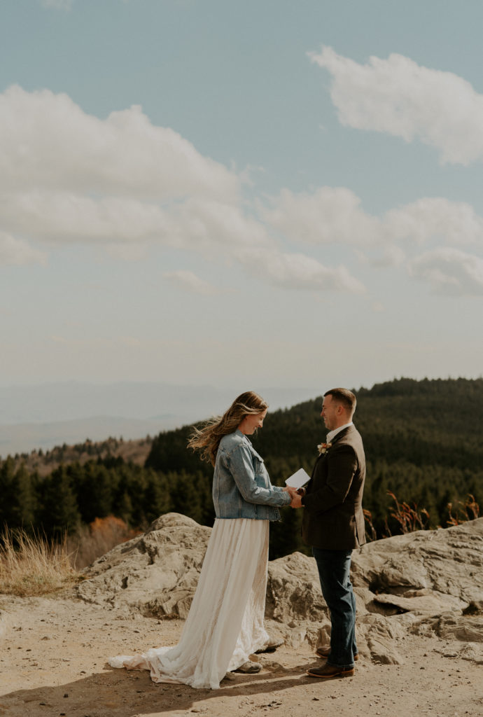 Bride and Groom reading vows on a mountain top together 
