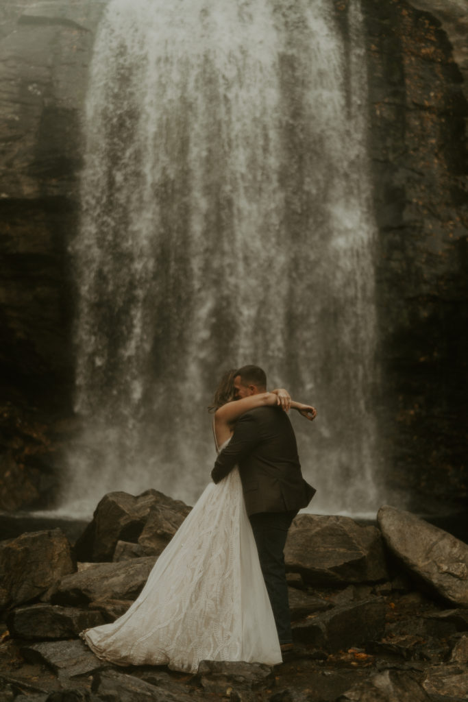 A man and a woman elope at a waterfall.