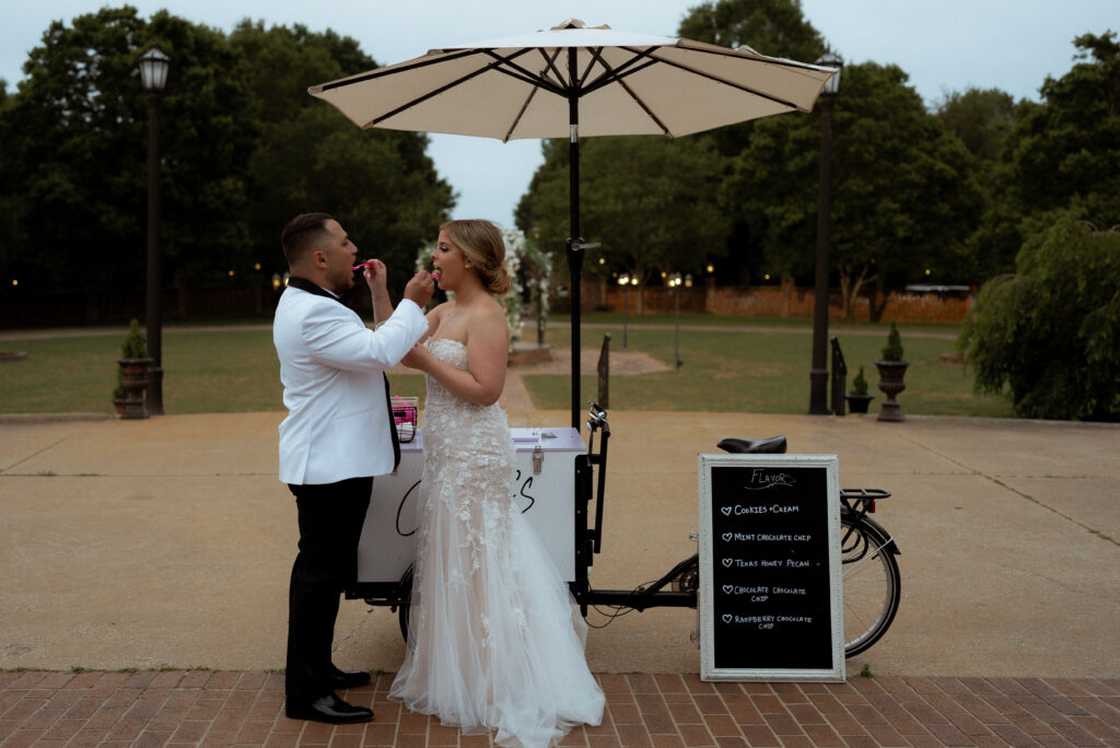 A couple enjoying ice cream instead of cake on their wedding day