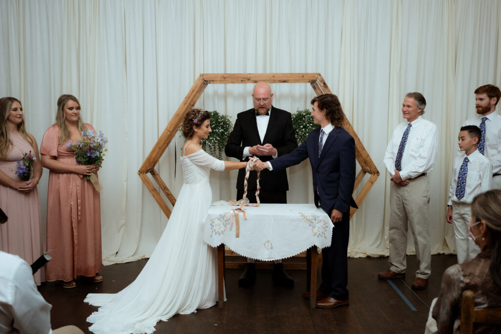 A unique wedding idea of hand fasting during a bride and groom's wedding day ceremony.