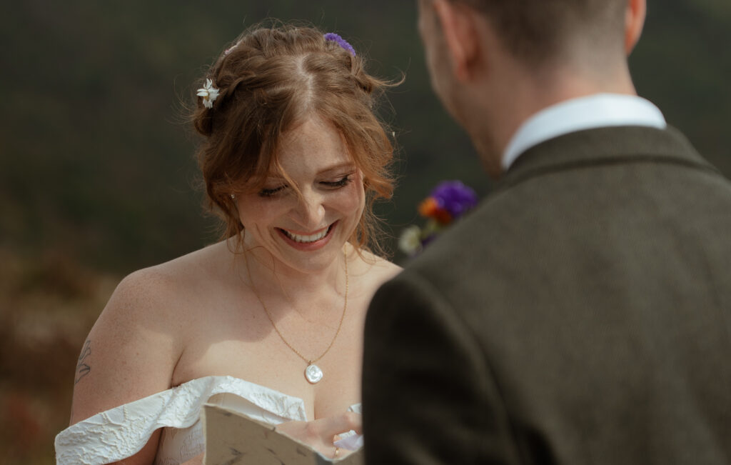 A couple exchanging vows in the midday sun on a mountain top 