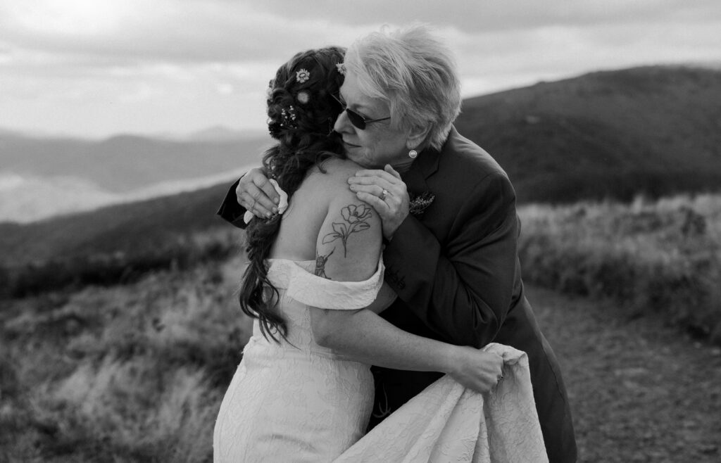 A mother in law hugging her daughter in law after a mountain top ceremony 