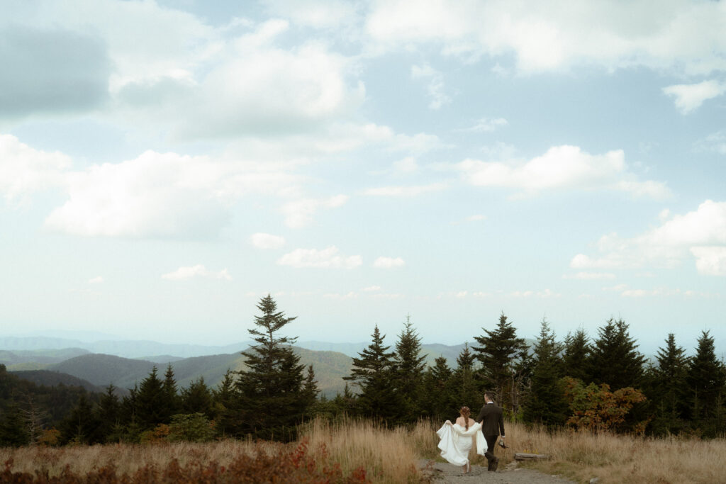 A just married running on a mountain top together in the Blue Ridge Mountains