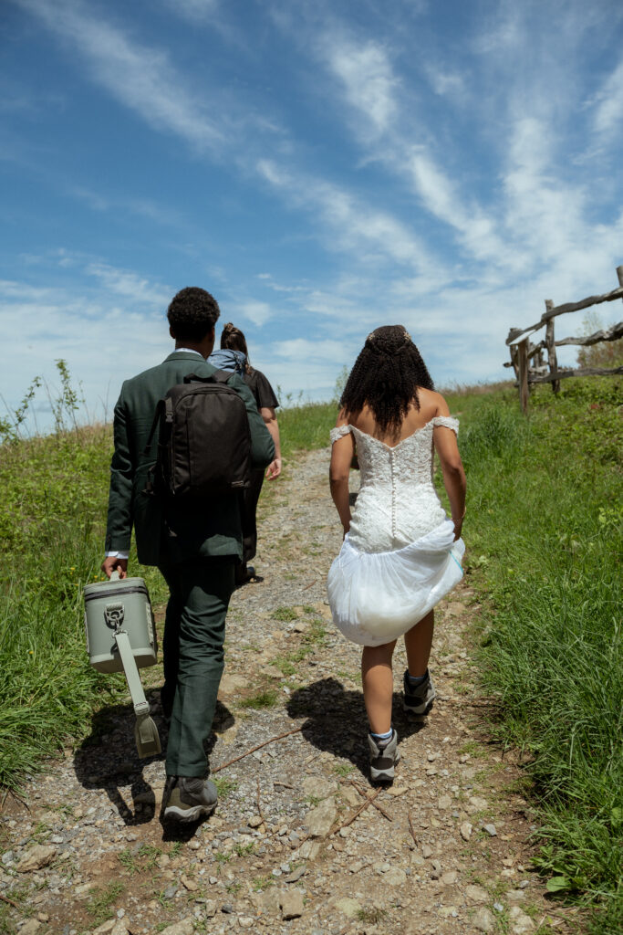 A couple and their officiant hiking to the top of Max Patch for their ceremony